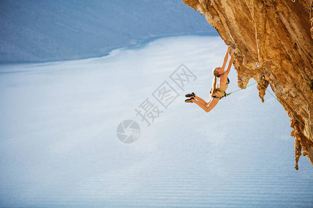 女攀岩者在悬崖上具有挑战路线上图片