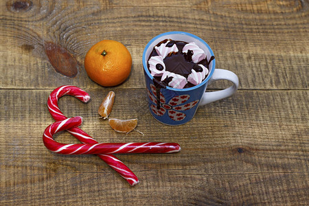 带糖果和棉花糖的热巧克力木本底的橘子图片
