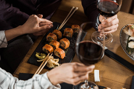 部分看一对在餐馆饮酒和吃寿司时图片