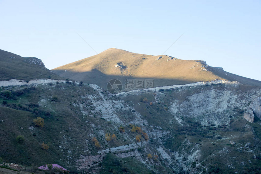 山和草甸的雄伟景观骑行山路在高山的雾蒙的山路多云的天空与山路图片