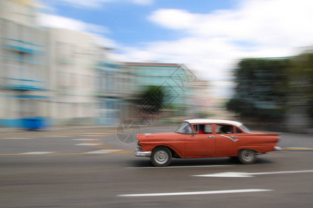 在古巴哈瓦那街上运行的闪亮红色老式汽车图片