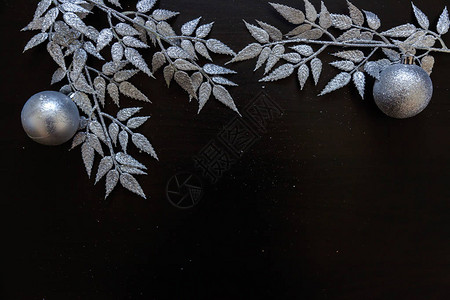 圣诞构图框架由冬季物品银枝小玩意和深黑色背景上的球制成背景图片