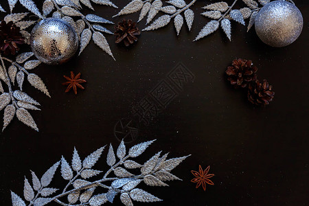 圣诞新年构图框架由冬季物品银枝小玩意和深黑色背景上的球制成图片