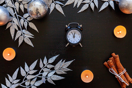 圣诞新年作文冬季物品蜡烛时钟银枝小玩意和深黑色背景上的球图片