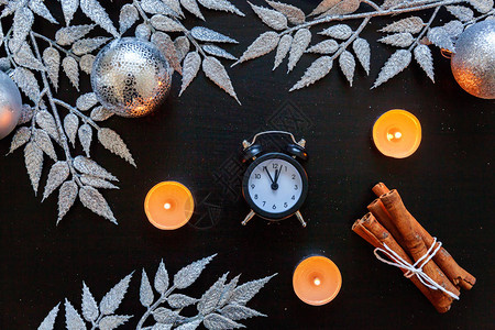 圣诞作文冬季物品蜡烛时钟银枝小玩意和深黑色上的球图片