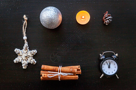 圣诞新年作文冬季物品时钟蜡烛冷杉树枝小玩意和深黑色背景上的球图片