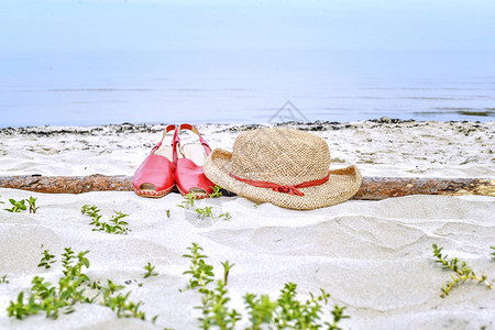 草帽和凉鞋躺在沙图片