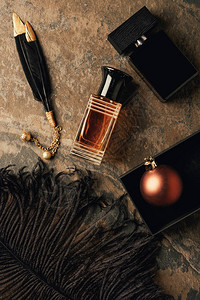 香水装饰黑色羽毛和闪亮圣诞球的顶视图图片