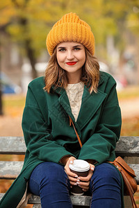 美丽的年轻女子秋天公园的木板凳图片