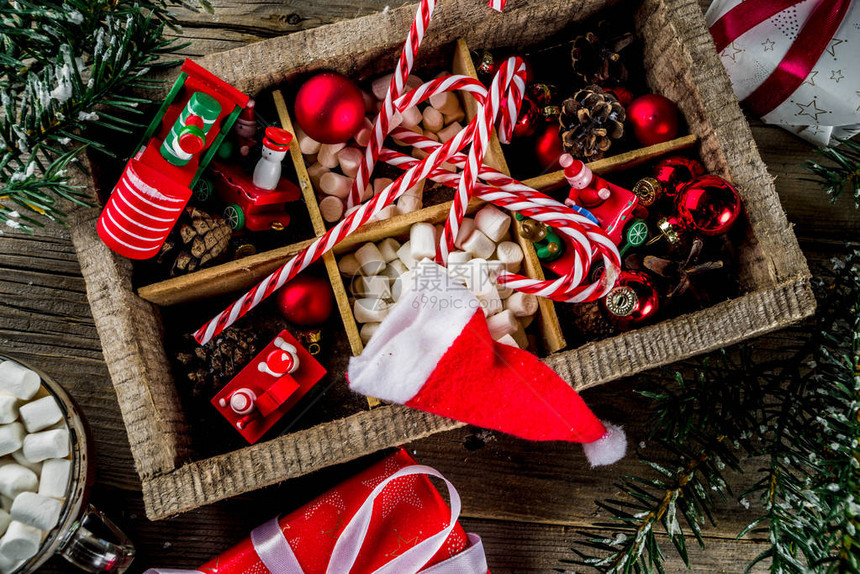 经典的圣诞背景圣诞树装饰品和树枝儿童新年玩具糖果手杖松果圣诞帽和旧木桌顶视图复制空图片