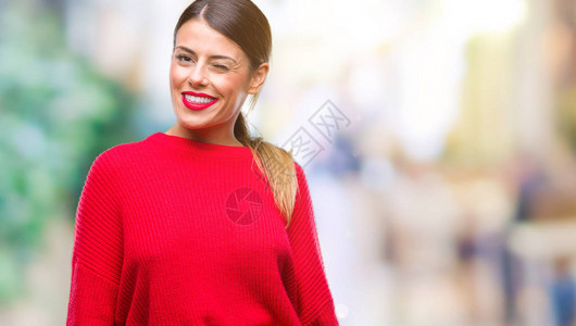 穿着冬毛衣的年轻女商人在孤立的背景上眨眼以感的表情欢乐和快乐的面孔图片