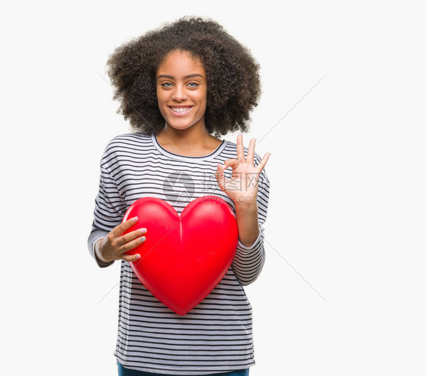 年轻美籍女深爱着红色的心在孤立的背景中相爱使用手指做好标记图片