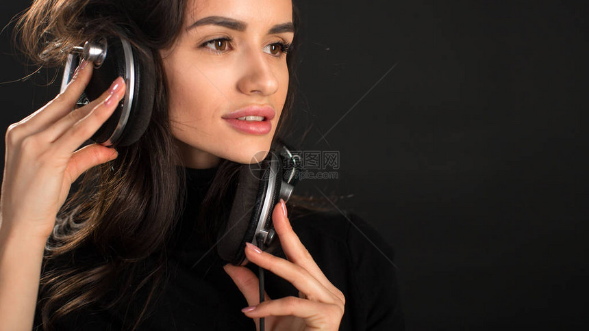 听迪斯科舞曲的DJ女孩在演播室装扮黑暗背景图片