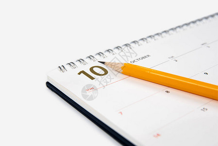 十月日历和白色背景上的铅笔图片