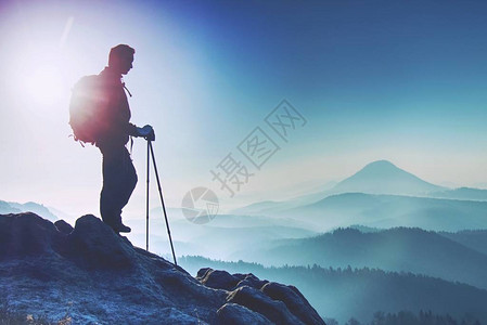 背着包站在山顶上欣赏山景的年轻人山顶上的徒步旅行者体育和积图片