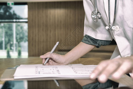 医生医生在医院写体检或处方单从业者在诊所的平板电脑上图片