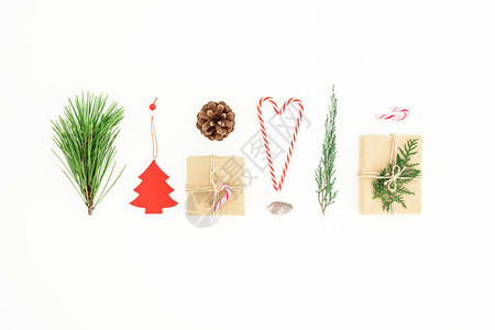圣诞礼物由糖果甘蔗松树枝和白背景的松果组成新年概念平图片