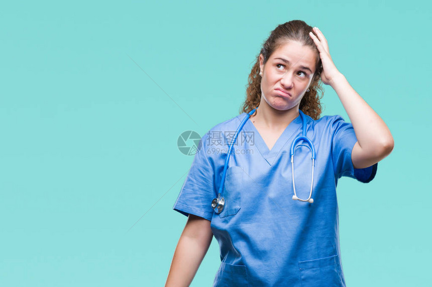 在孤立的背景下穿着护士或外科医生制服的黑发年轻医生女孩对问题感到困惑和好奇图片