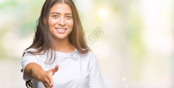 年轻美丽的阿拉伯女人在孤立的背景下微笑着友好地握手作为问候和欢迎图片