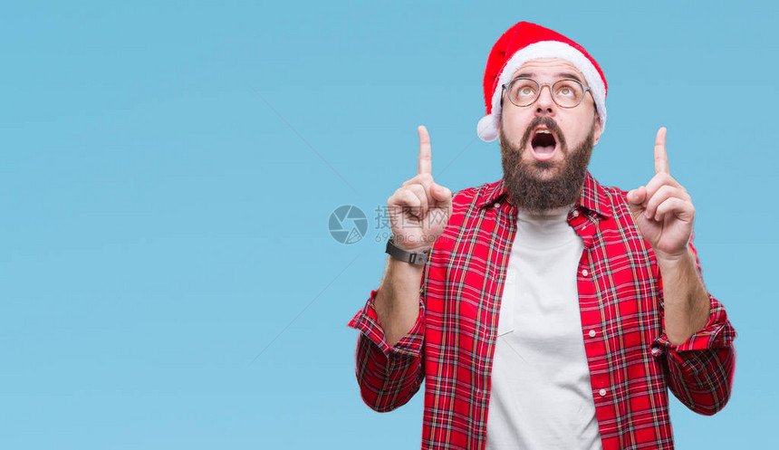身戴圣诞帽的年轻天主教男子在孤立的之下惊讶地抬头图片