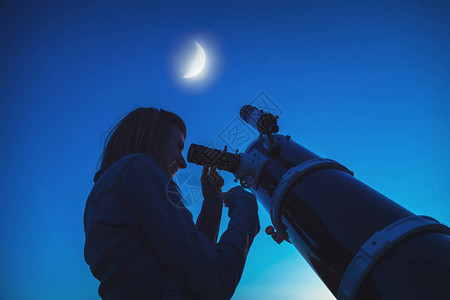 月亮在天上的女孩和望远镜的轮廓我图片