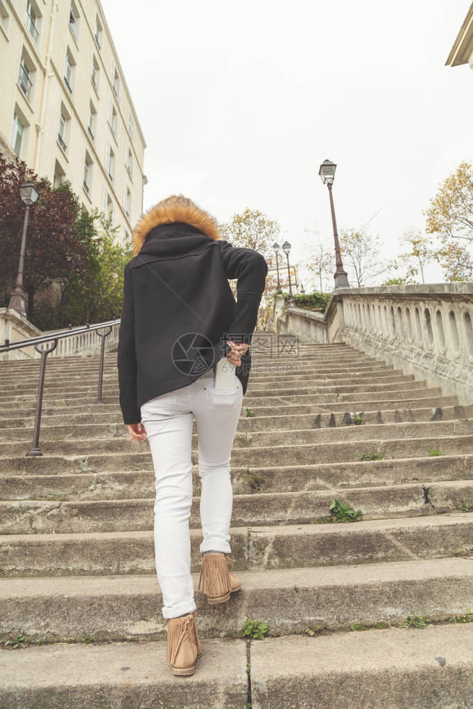 女人走在楼梯上然后把手机从口袋图片