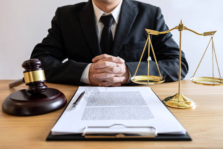 法律咨询和司法概念男律师或公证人处理重要案件的文件和报告以及木槌图片