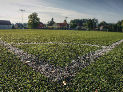 足球Fierld角绿色合成草坪橄榄球的白线涂料贴近角图片