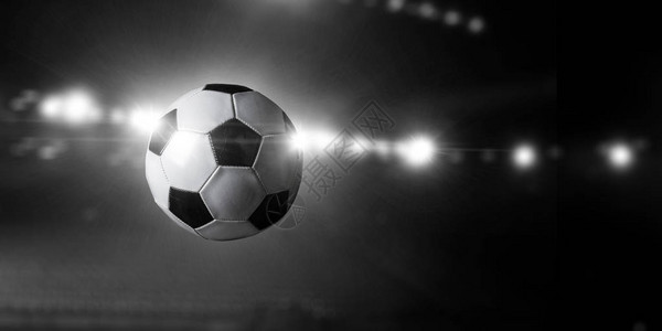 足球在体育场的灯光下飞过空中混合媒体图片