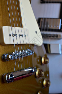 金顶和白色电吉他特写与P90拾音器琴身拾音器琴桥琴弦图片