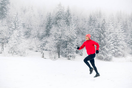 快乐的女孩在冬季山上的雪上奔跑运动健身图片