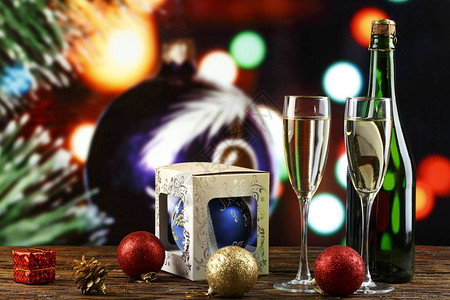 在眼镜和瓶子里的香槟和散景背下圣诞树上的玩具圣诞背景t图片