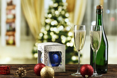 在眼镜和瓶子里的香槟和散景背下圣诞树上的玩具圣诞背景t图片