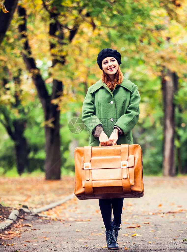 穿贝雷帽和大衣的红发女孩在秋季图片