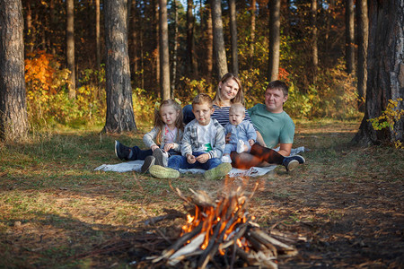 父亲母亲两个男孩和女孩在秋天森林图片