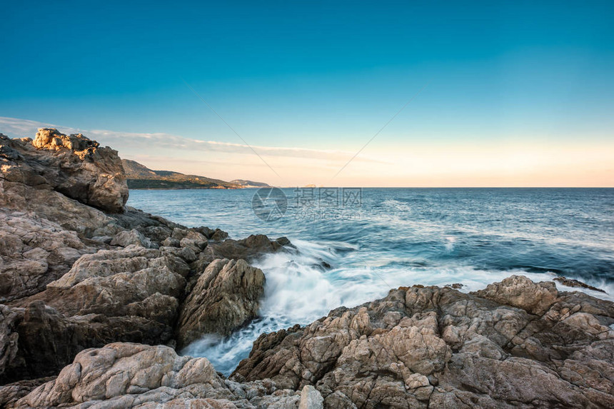 波浪冲洗到洛萨里科西卡的岩石海岸黎明时在遥远的图片