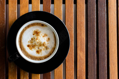 Cappuccino咖啡杯在棕色褐横线桌边图片