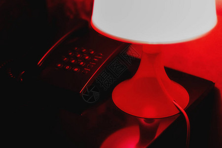 夜灯站在电话旁边的床边桌子上背景图片