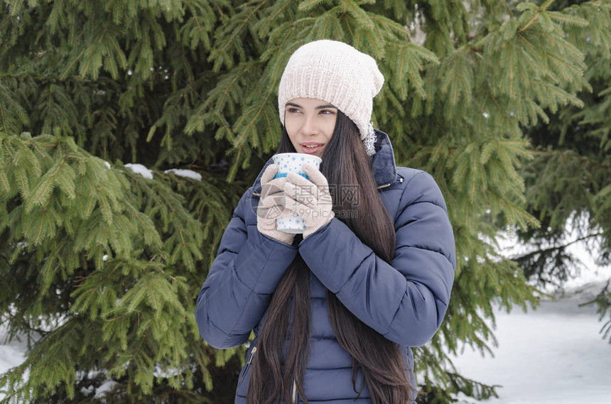 绿针背景下带热饮的少女保温杯冬日寒冷图片