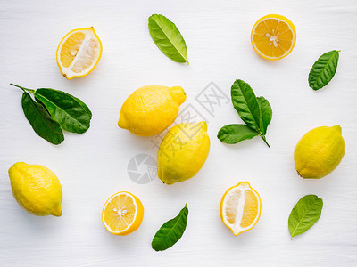 新鲜的柠檬和柠檬叶在白色木制背景上背景图片