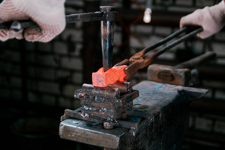 铁匠的工作区铁匠在锻造的铁砧上使用新锤子的红色热金图片