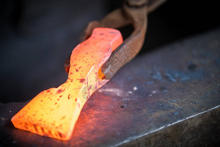 铁匠和铁砧铁匠在铁砧上使用新锤子的红色热金属工件图片