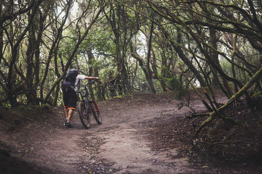 山上骑自行车的人在雨林图片