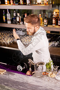 调酒师正在休息室的吧台制作鸡尾酒图片