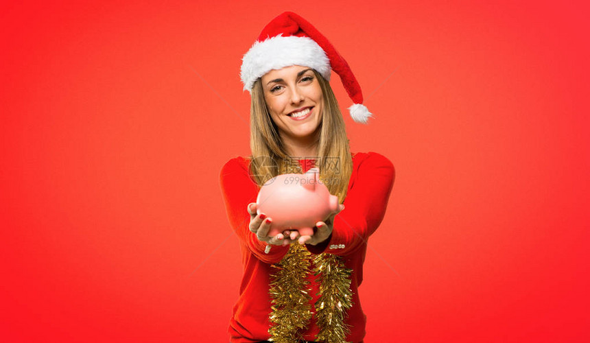 金发女人穿了衣服圣诞节假期的圣诞假带着小猪银行和快乐图片