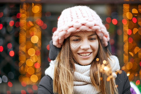穿着冬装的迷人笑脸金发美女在园林庆祝圣诞节的模糊不清图片
