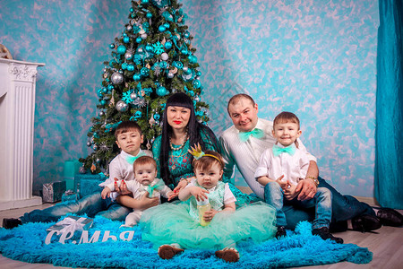 一个大家庭聚集在新年树周围圣诞快乐和新年快乐父母和孩子图片