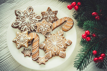 圣诞自制的姜饼干和白木本底的圆形树枝平图片