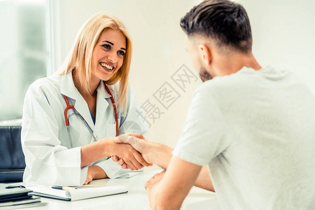 女医生在医院办公室与男病人握手医疗保健和图片