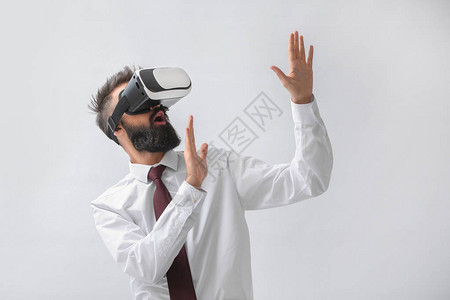商人在光背景上佩戴虚拟现实眼图片